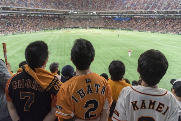 Fans watch baseball at the Tokyo Dome.