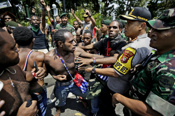 Papuan activists scuffle with police and soldiers near the presidential palace in Jakarta, in 2019, following the unrest at Surabaya.