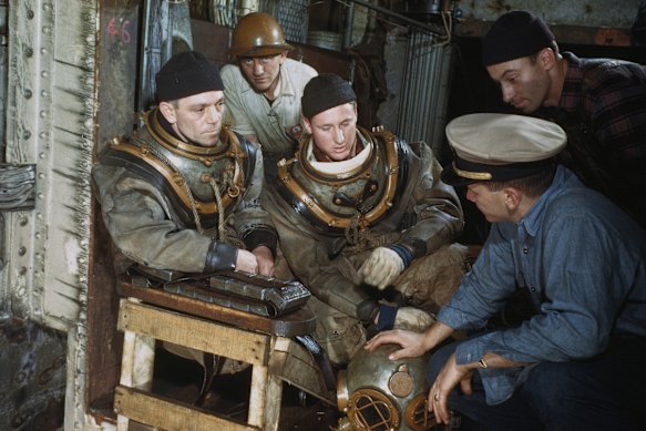 Navy divers prepare to inspect the ship after the fire.