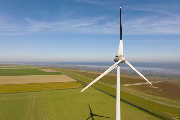 A wind turbine with one blade painted black to reduce collisions with birds.