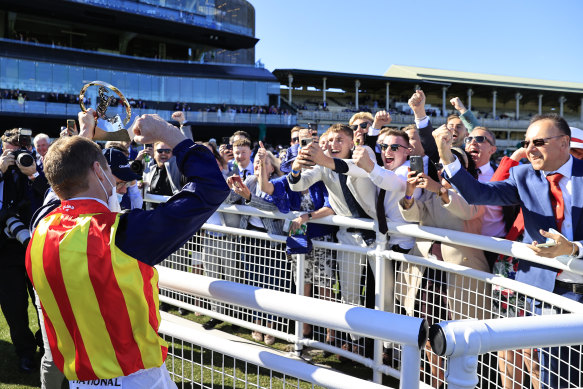 James McDonald shows off his trophy for The Everest to the crowd at Randwick on Saturday.