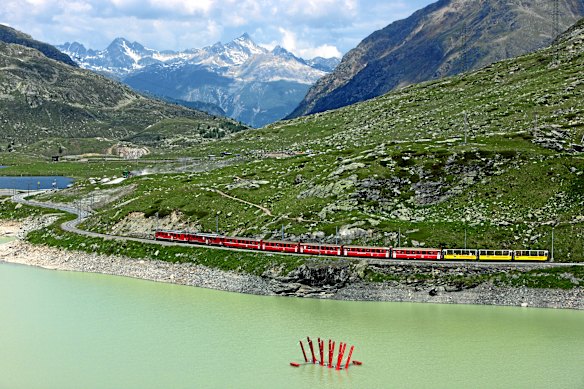 The Rhaetian Railway’s summer windowless yellow open scenic carriages.