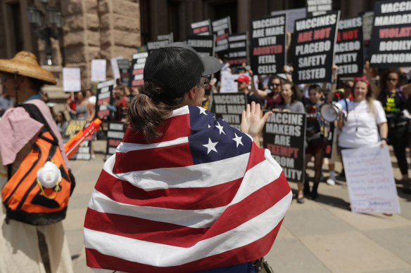 Ignoring social distancing and mandates to wear masks for other face coverings, protesters attend an "Open Texas" rally at the Texas State Capitol on Saturday.