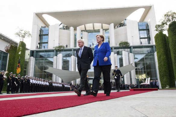 Germany's Chancellor Angela Merkel and British Prime Minister Boris Johnson walk the red carpet during a welcome ceremony in Berlin.