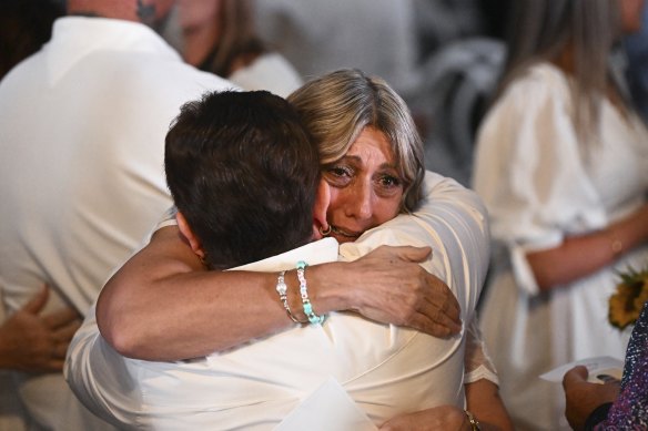 Luke Davies’ mother, Sandra, is hugged by a mourner after a memorial service.