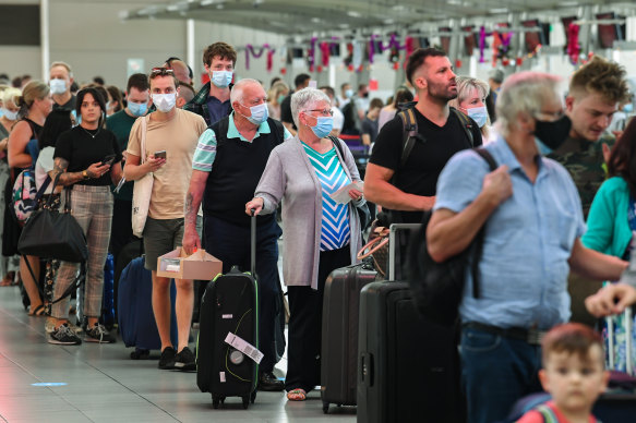 Airline passengers wait in line to check in at Sydney’s Kingsford Smith domestic airport on Friday. 