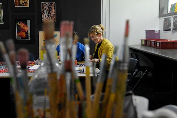 Teacher Sharon Martin with a young person during an art class at Reiby.