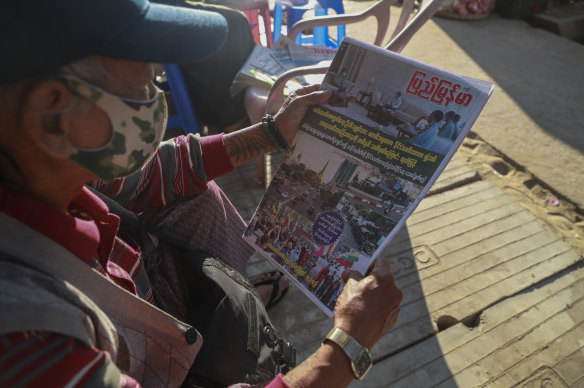 A man reads at a newspaper, which reports on the military coup, in Yangon, Myanmar on Tuesday.