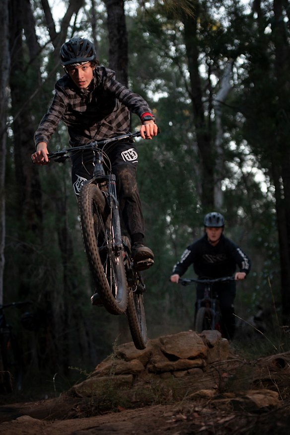 Silas Statheos and Noah Przydacz ride a downhill trail after a day of home learning in the lower Blue Mountains.