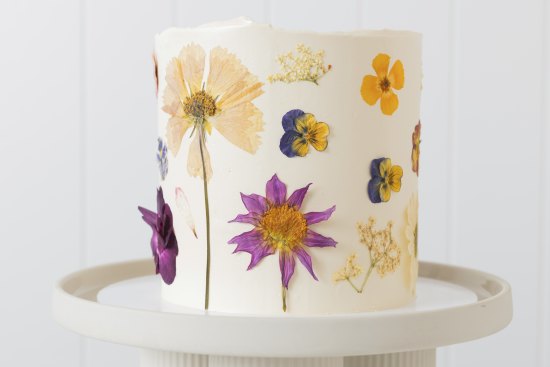 A custom cake decorated with edible flowers.