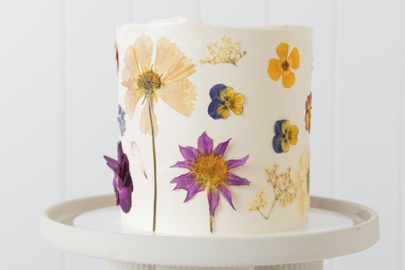 A custom cake decorated with edible flowers.