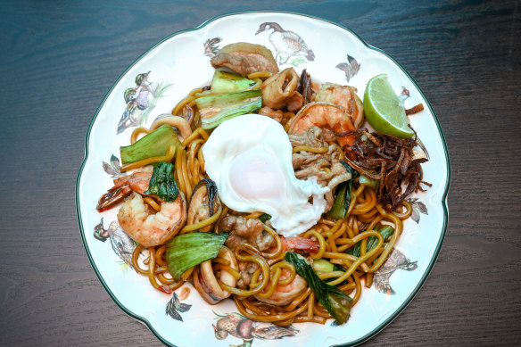 Hokkien noodles at Pa Tong are stir-fried with prawns, mussels and sliced pork, and topped with a runny egg.