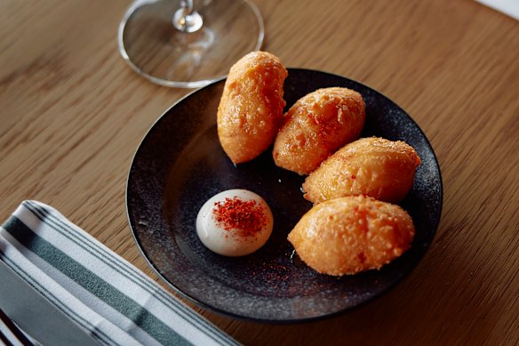 Smoked cheddar puffs with hot honey at 81 Bay.