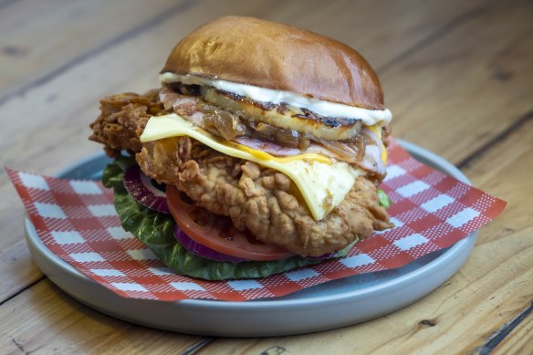 The secret 3-12 burger with fried chicken breast, cheese, charred pineapple, caramelised onion and bacon.