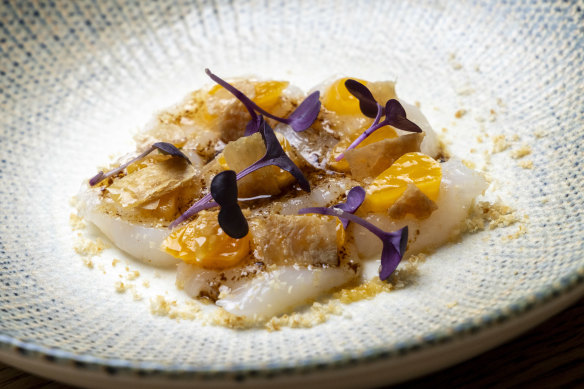 The go-to dish: raw scallops with black garlic, mandarin and chicken skin.