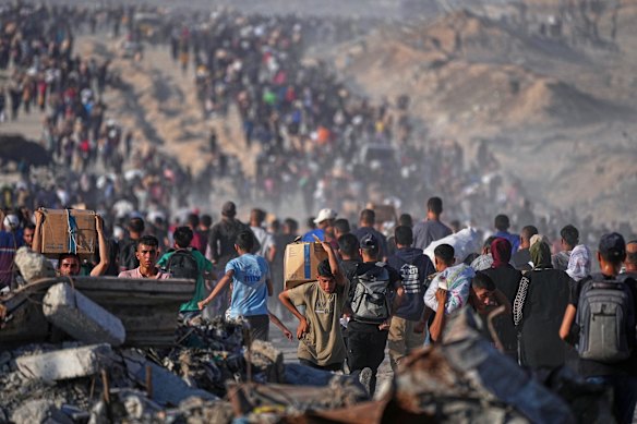 Palestinians carry sacks and boxes of food and humanitarian aid in northern Gaza this week.