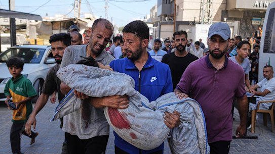 Relatives carry the body of 13-year-old Seraje Ebrahim, who was killed in an Israeli strike on a drinking water distribution point on Sunday.