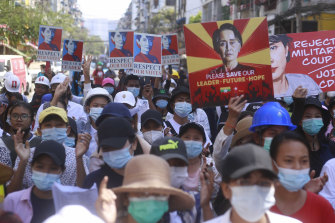 Anti-coup protesters hold up images of deposed leader Aung San Suu Kyi as they gather in Yangon, Myanmar, on Friday.