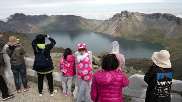 Chinese tourists take in the sight from a viewing platform overlooking the caldera of Mount Paektu near Samjiyon in North Korea. 