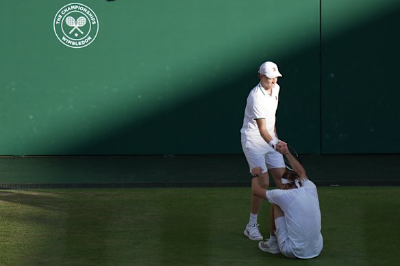 Sinner helps Zverev up after a fall.