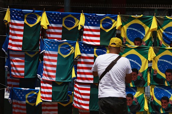 A vendor displays dual flag jerseys featuring the Brazilian and U.S. flag, outside the condominium where Bolsonaro is under house arrest.