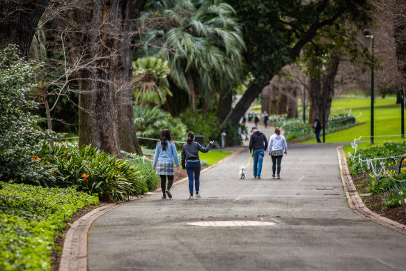 People enjoying a walk in the Fitzroy Gardens on Monday