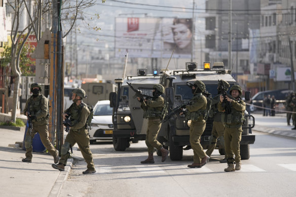 Israeli soldiers take up positions at the scene of a Palestinian shooting attack at the Hawara checkpoint, near the West Bank city of Nablus.