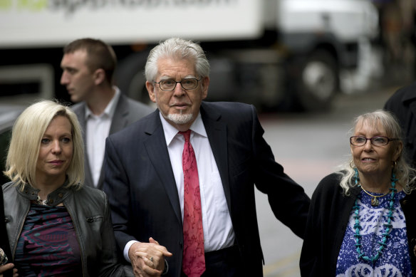 Rolf Harris arrives for his trial with wife Alwen Hughes, right, and daughter Bindi at Southwark Crown Court in London in 2014.