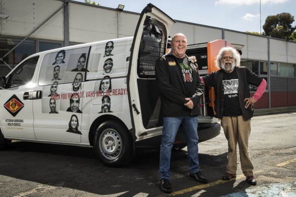 Victorian Aboriginal Health Service general manager Gavin Brown and Uncle Jack Charles pose for a photo with the service’s new mobile vaccination van.