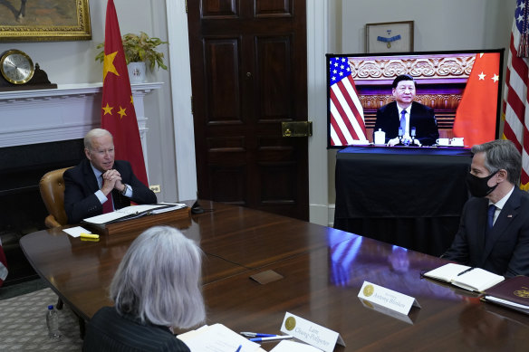 US President Joe Biden, left, meets virtually with Chinese President Xi Jinping on Monday.