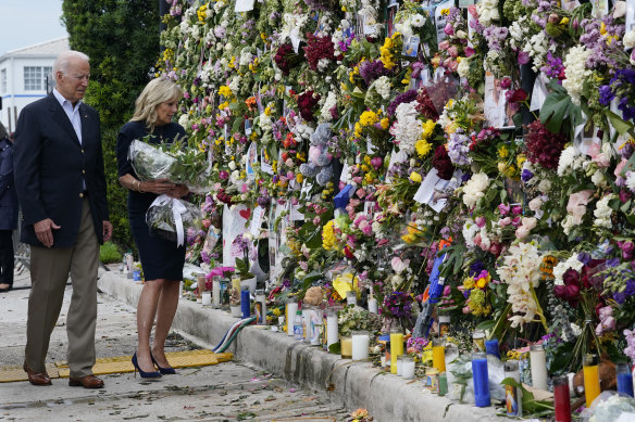 President Joe Biden and first lady Jill Biden visit memorial wall covered in flowers and photos of the missing.