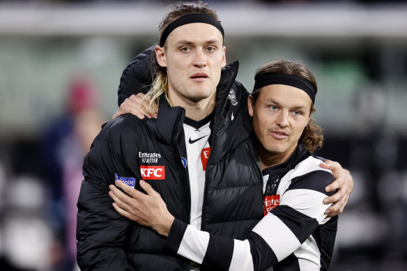 Injured Collingwood skipper Darcy Moore with Jack Ginnivan.