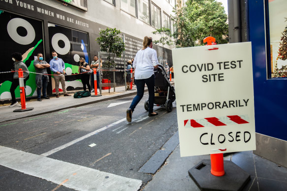  Photo shows people queuing outside the COVID testing site on Bourke Street in Melbourne.