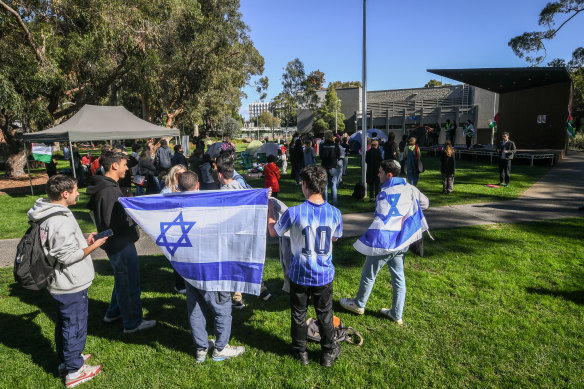Protesters with Israeli flags launch a counter-protest at the Monash University encampment on Wednesday.