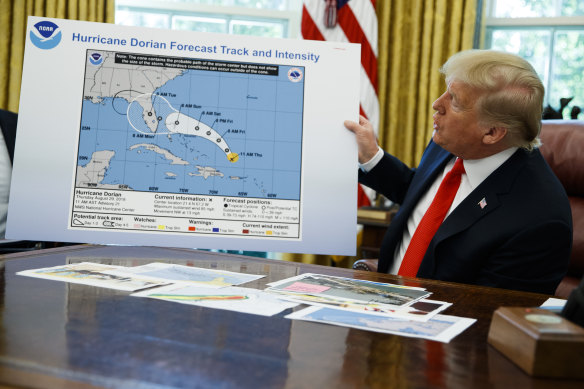 President Donald Trump holds the chart with the extended impact zone of Hurricane Dorian in the Oval Office in September.