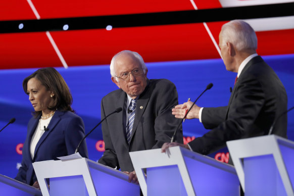 Senators Kamala Harris and Bernie Sanders listen to former vice-president Joe Biden.