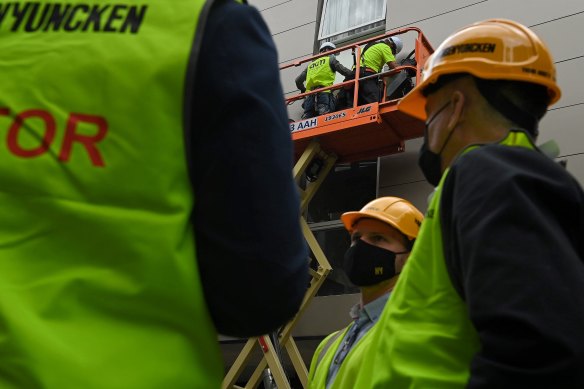 Workers remove cladding from the Darlington apartment building. 