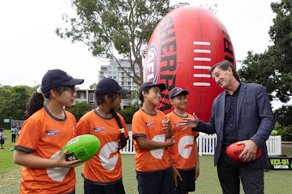 AFL CEO Andrew Dillon
 speaks to school children as he poses with students from Rosehill Public School during an AFL School Connect visit to Rosehill Public School. 