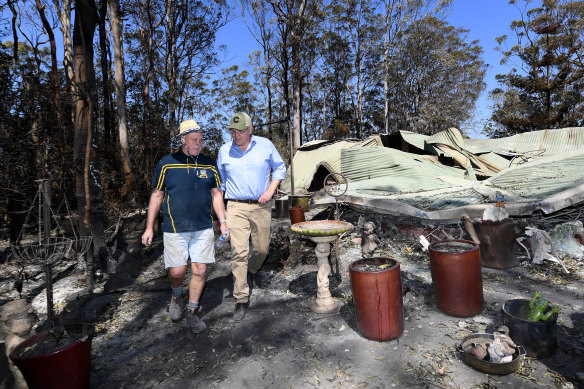 Property owner Stuart Skeen walks with Prime Minister Scott Morrison through his burnt-out property at Binna Burra in the Gold Coast Hinterland on Friday, September 13, 2019. 