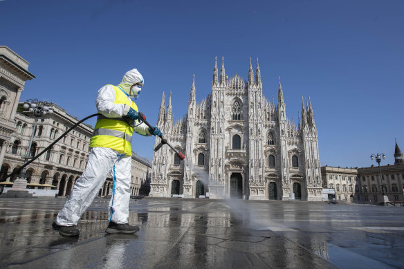 A worker sprays disinfectant to sanitise Duomo square in Milan, Italy in March.