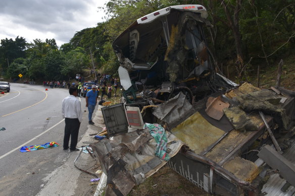 The wreckage of a passenger bus that was involved in a collision with a trailer truck lies on the side of the highway in Gualan in Guatemala.