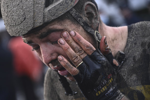 Belgian superstar Wout van Aert wipes mud from his eyes after the race that conditions made treacherous. 