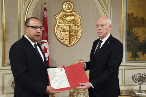 Tunisian President Kais Saied, right, appoints Interior Minister Hichem Mechichi as the new Prime Minister in July.