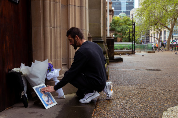A man pays his respects to the Queen by laying flowers at St Andrew’s Cathedral on George Street last week.