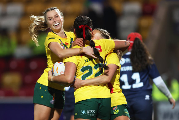Olivia Kernick celebrates with teammates after Australia’s 13th try.