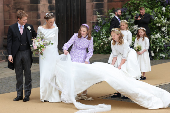 Bridemaids fold out the veil of Olivia Grosvenor, Duchess of Westminster, after her wedding to Hugh Grosvenor, Duke of Westminster, at Chester Cathedral.