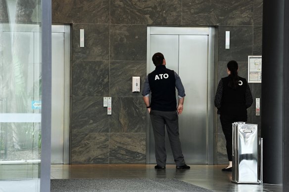 ATO officers enter Number 10 Herb Elliott Drive, the headquarters of businesses related to the Plymouth Brethren Christian Church, in Olympic Park, on Tuesday.