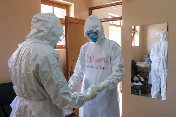 Ekim ayında Uganda'nın Entebbe kentinde bir Ebola kurbanıyla temas halinde olan bir hastayı ziyaret etmeden önce koruyucu ekipman giyen doktorlar birlikte dua ediyor.
