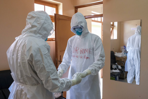 Doctors wearing protective equipment pray together before they visit a patient who was in contact with an Ebola victim in Entebbe, Uganda, in October.