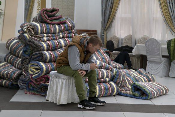 A Russian man rests in at temporary accommodation facility after crossing the border into Kazakhstan.